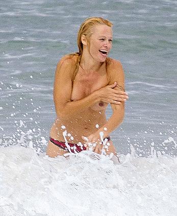 Busty Pamela Anderson goes topless on a beach in France