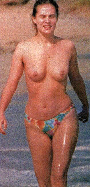 Emmanuelle Seigner caught topless on a beach